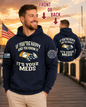Man wearing a navy hoodie with a humorous message, standing on a dock with an American flag in the background.